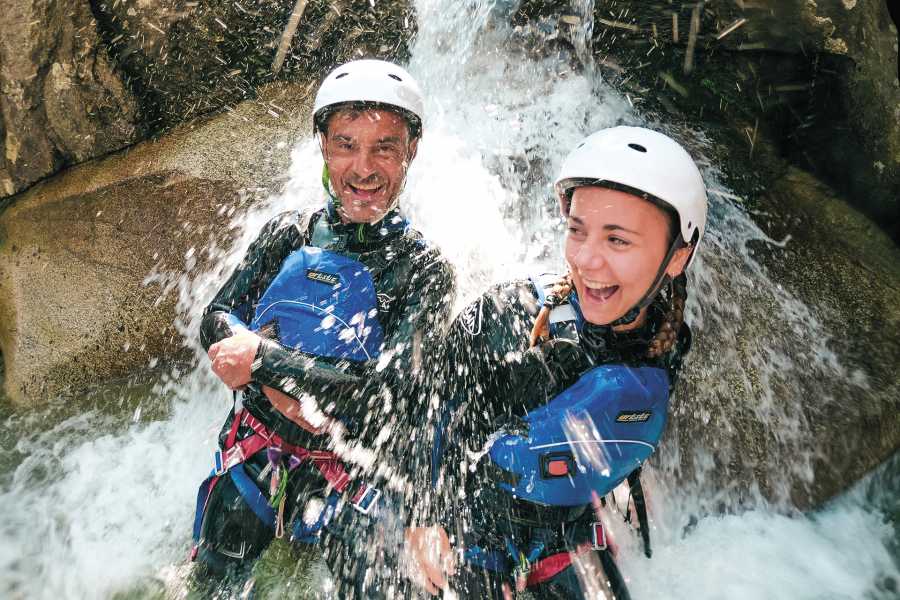 Canyoning in Grimsel, water fun, people with helmets and wetsuits