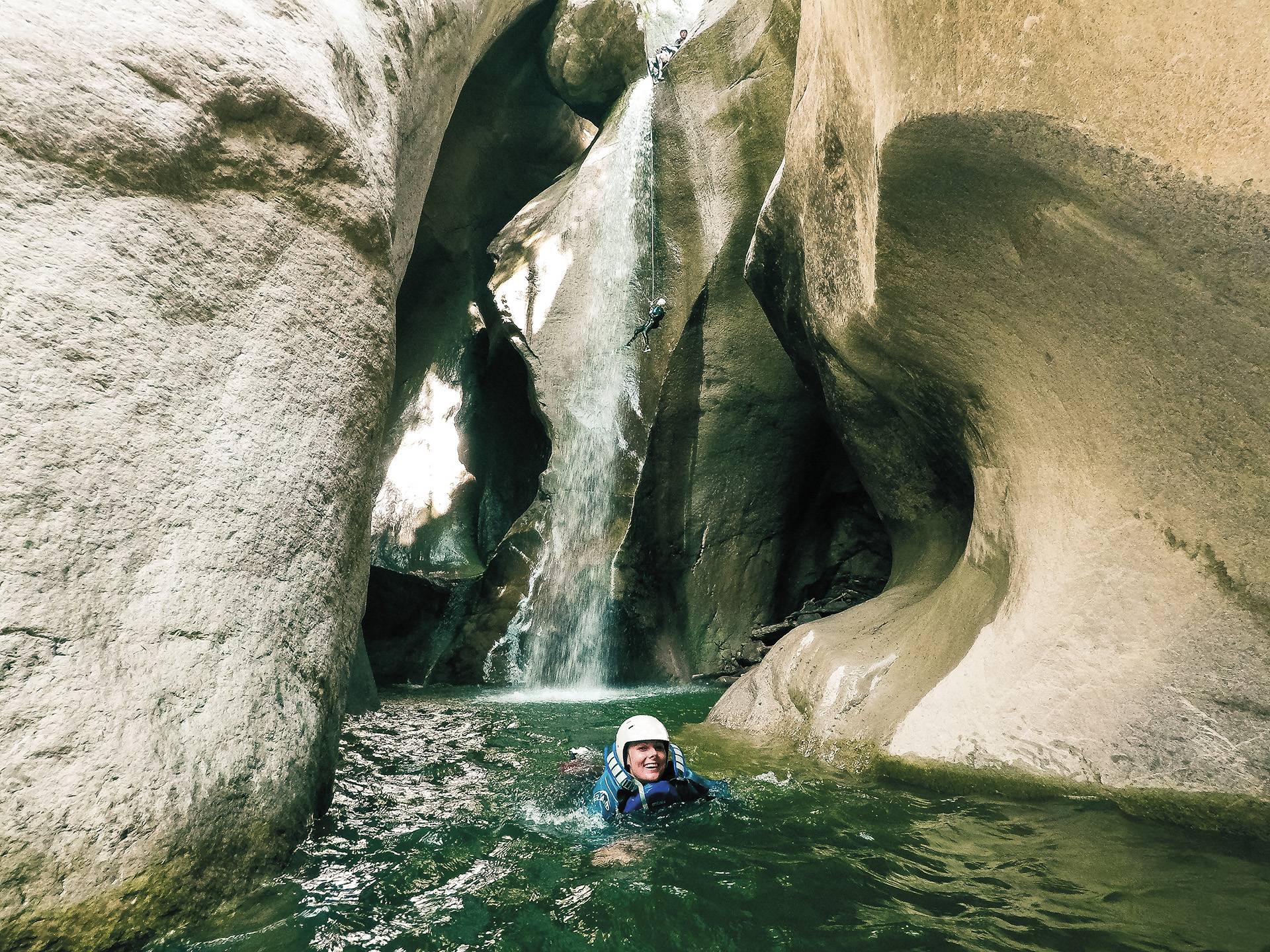 Chli Schliere Abseilen und Schwimmen in der Schlucht, umgeben von steilen Felsen und Wasserfall.