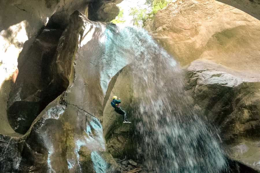 Abseilen Wasserfall Chli Schliere, Kletterer in Wassermenge, felsige Umgebung