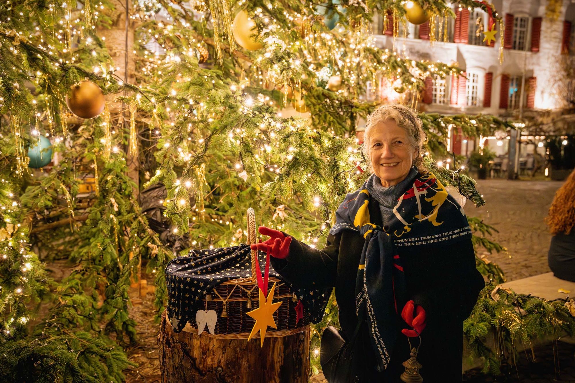 Marché de Noël de Thun avec décoration festive, lumières et visiteurs joyeux.