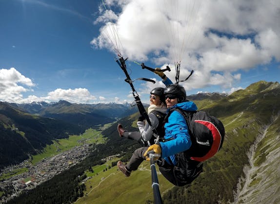 Voo de parapente em Klosters sobre as montanhas com duas pessoas.