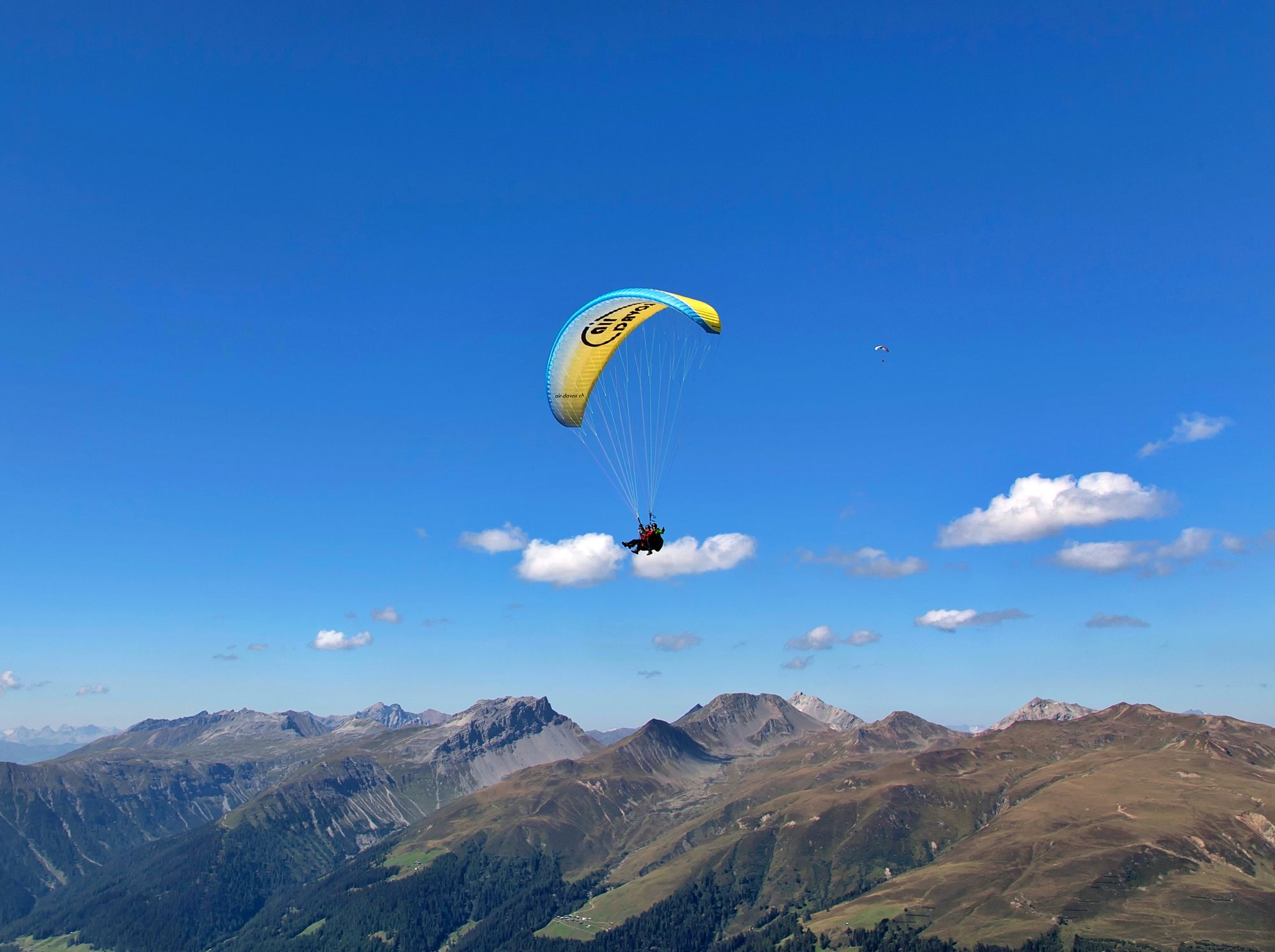 Parapente à Davos au-dessus des montagnes en été, ciel bleu, montagnes vertes