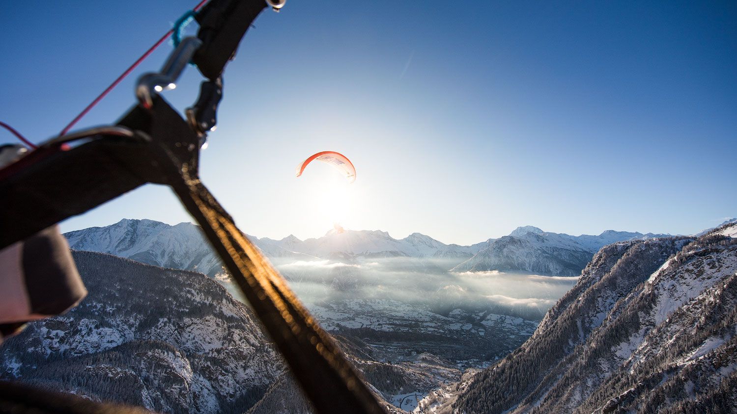 الطيران بالمظلات فوق المناظر الجبلية في الألب عند شروق الشمس
