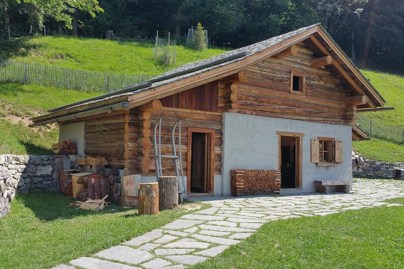 Houten Alphütte Heididorf in een landelijke omgeving met tuin.
