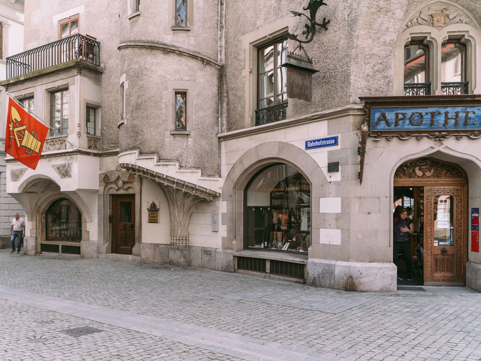 역사적인 외관과 기차역 거리의 간판이 있는 루체른의 옛 약국