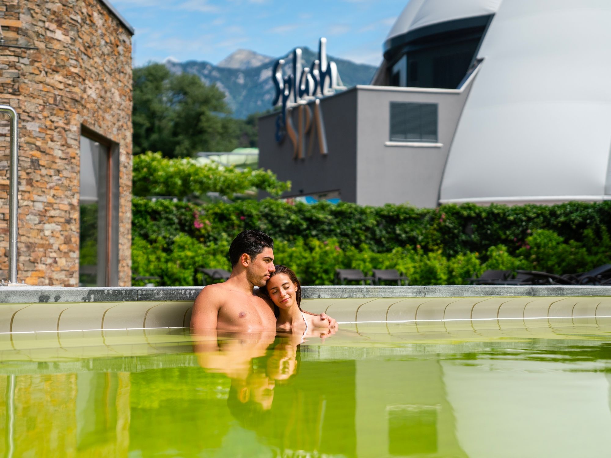 Ευεξία και σπα εξωτερικός χώρος με ζευγάρι στην εξωτερική πισίνα σε ηλιόλουστη μέρα.
