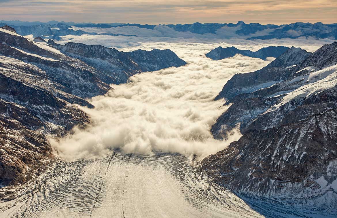 إطلالة على الجليد من مروحية فوق وادٍ ملبد بالغيوم