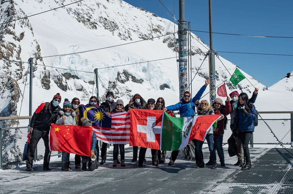 Den otevřený den na Jungfraujoch s skupinou, lidé drží vlajky