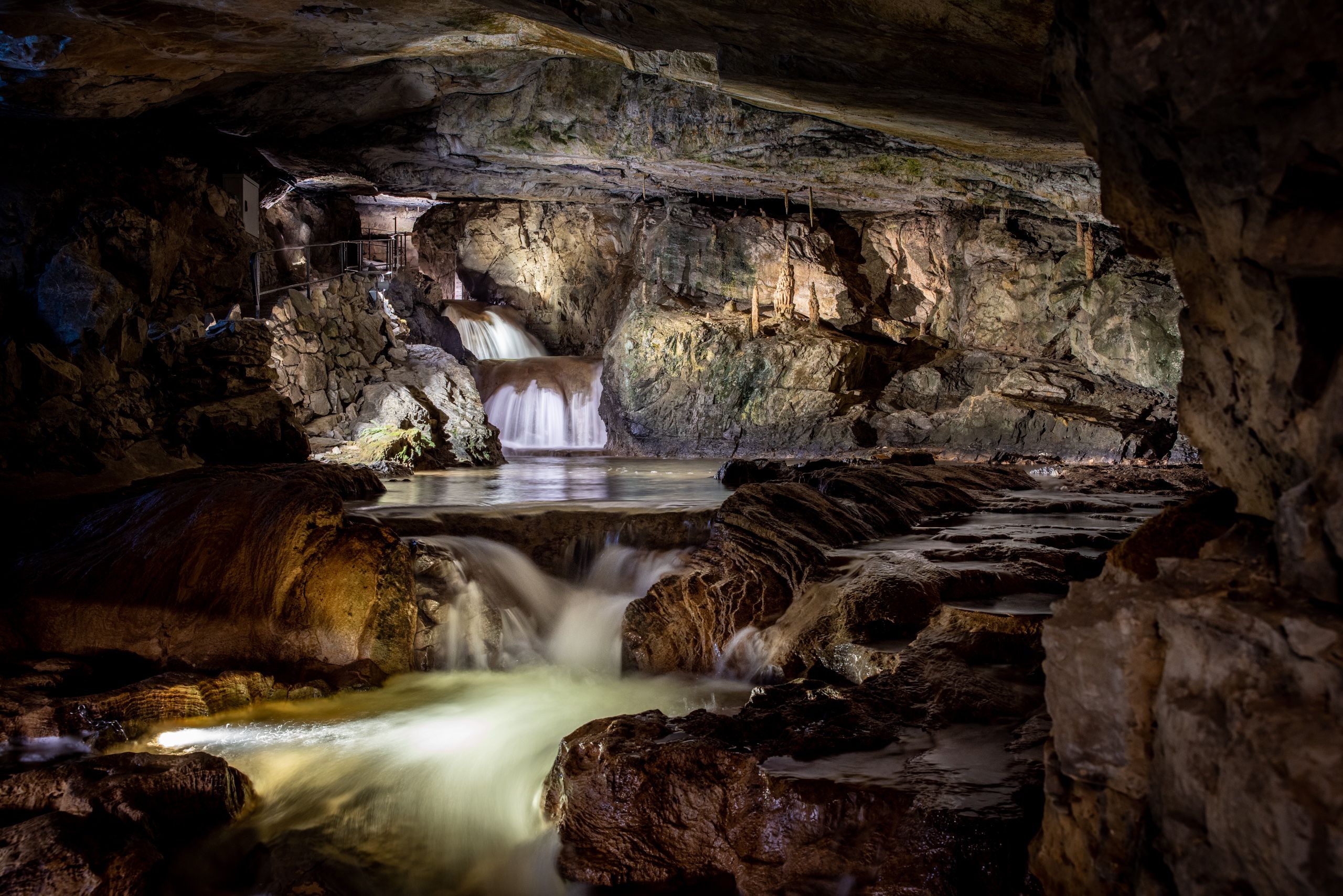 Beatushöhlen: Wasserfall im Inneren einer Höhle, umgeben von beeindruckenden Felsen und Natur.