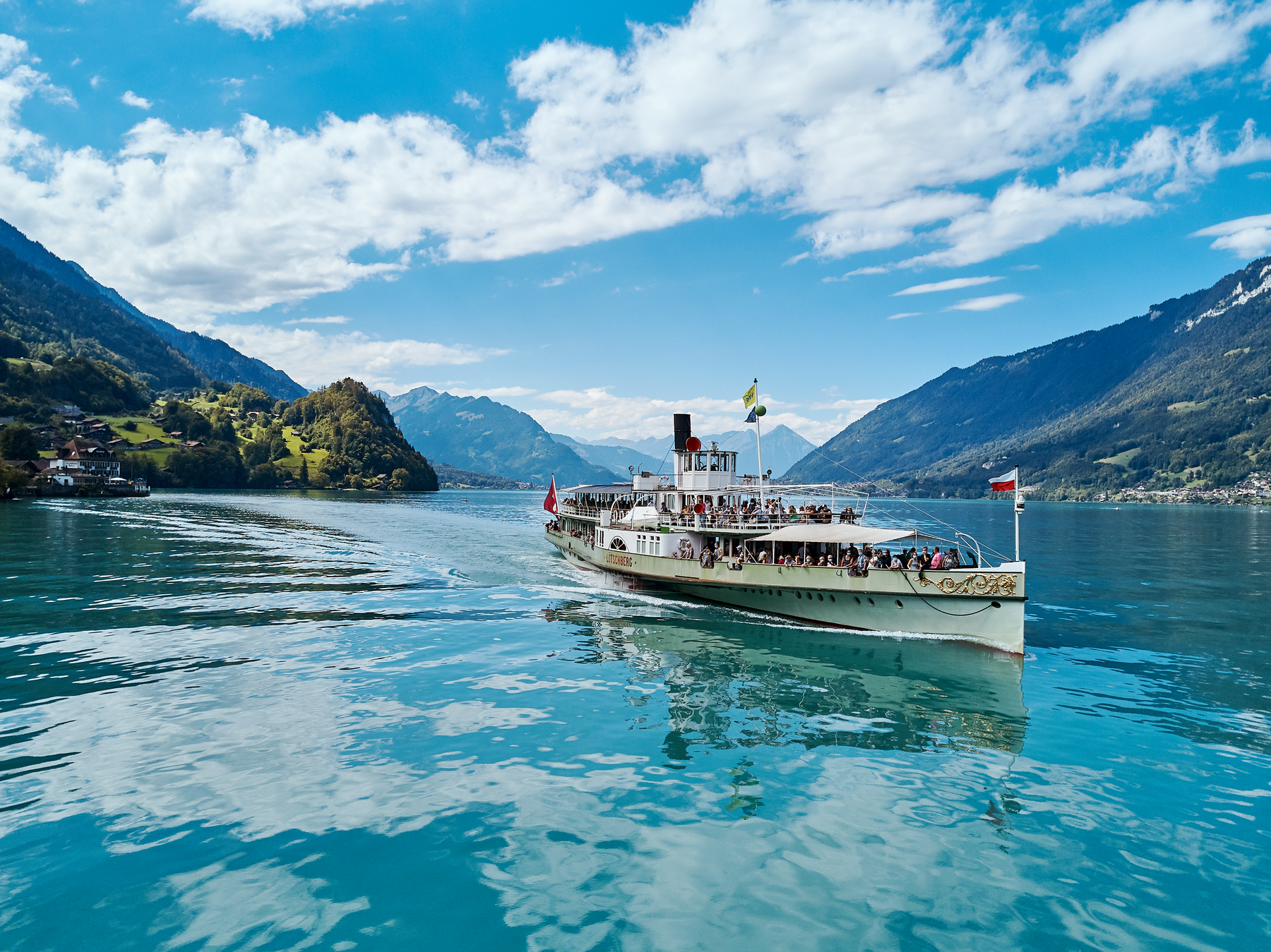 Brienzersee Schifffahrt, Boot auf dem Wasser, Berge im Hintergrund, blauer Himmel