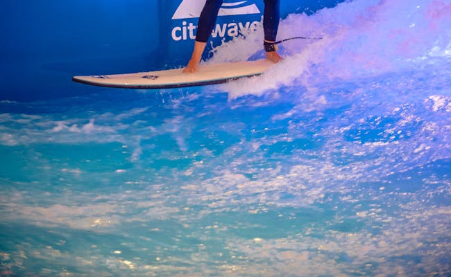 Surfen auf der Citywave mit blauer Wasseroberfläche und Spritzern.