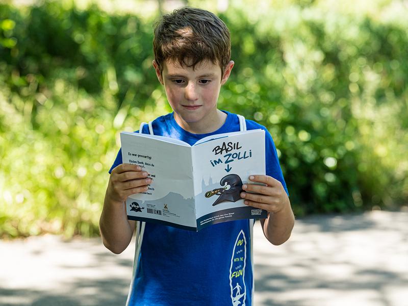 Ζωολογικός Κήπος Basel: Παιδί διαβάζει έξω, ενδιαφέροντα ζώα και περιπέτειες σε μια εκδρομή.