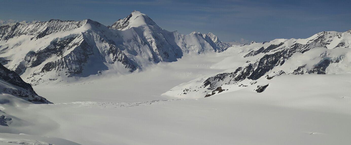 Gruppenunterricht Ski Kinder im Bergpanorama von Grindelwald mit schneebedeckten Bergen.