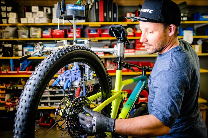 दावोस में बाइक किराए पर लेना: एक आदमी उपकरण के साथ कार्यशाला में साइकिल की मरम्मत कर रहा है।