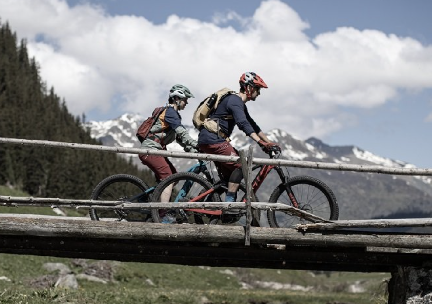 Mountain bike tour in Davos, cyclists on a wooden bridge, alpine surroundings