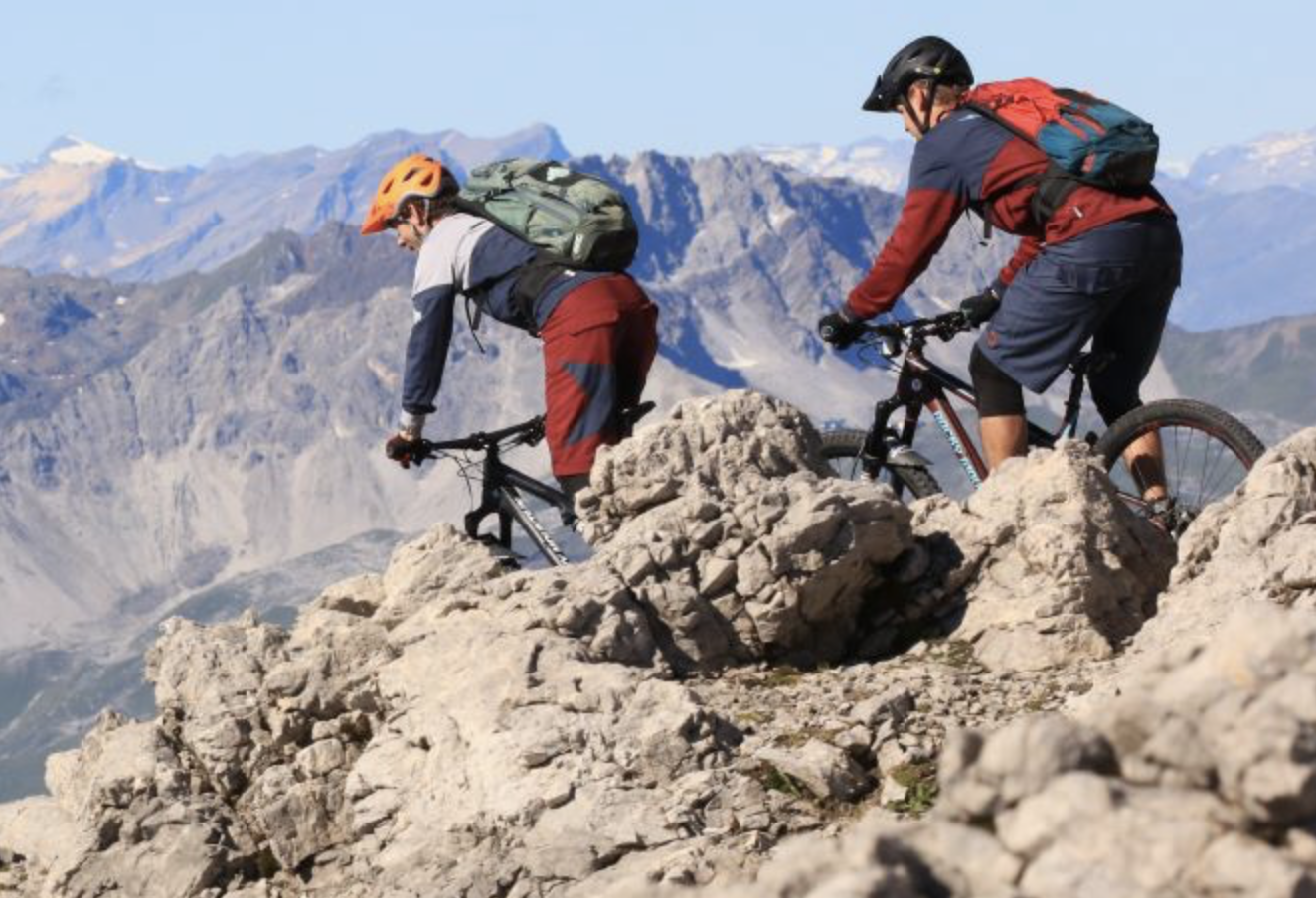 Mountainbike Graubünden su terreno roccioso con vista lontana