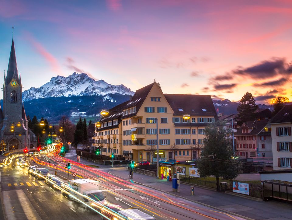 Luzern bei blauer Stunde mit Bergsicht, Verkehr und Häusern.