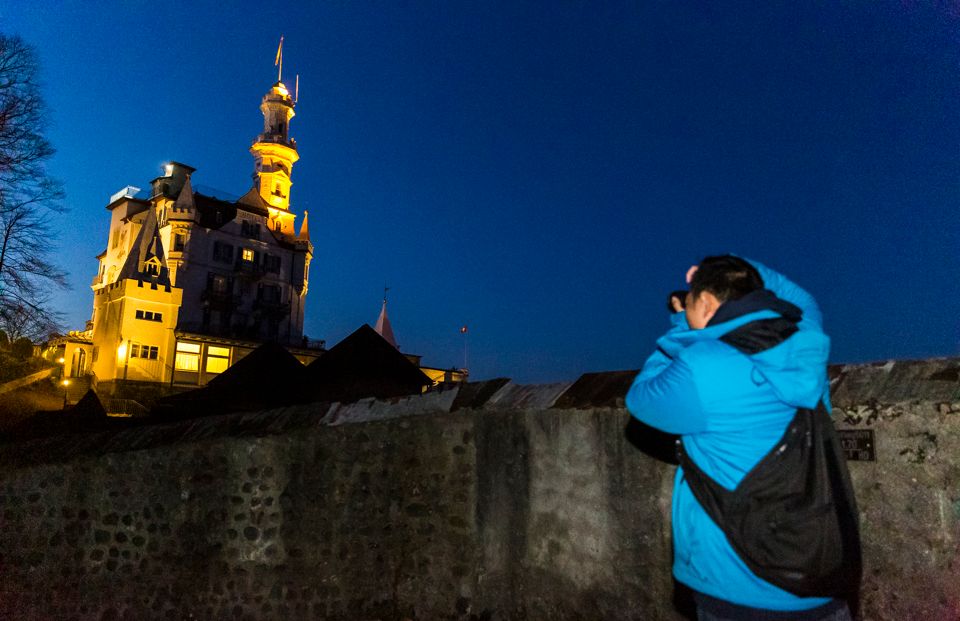 Fotograf in blauer Stunde vor dem Turm in Luzern. Das Licht beleuchtet die historische Architektur.