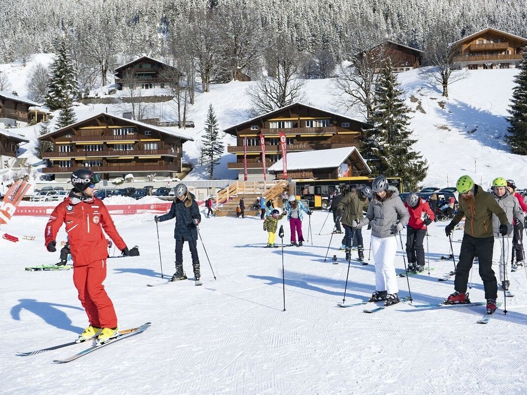 Esquiar em Grindelwald sob um sol radiante, muitos esquiadores na pista