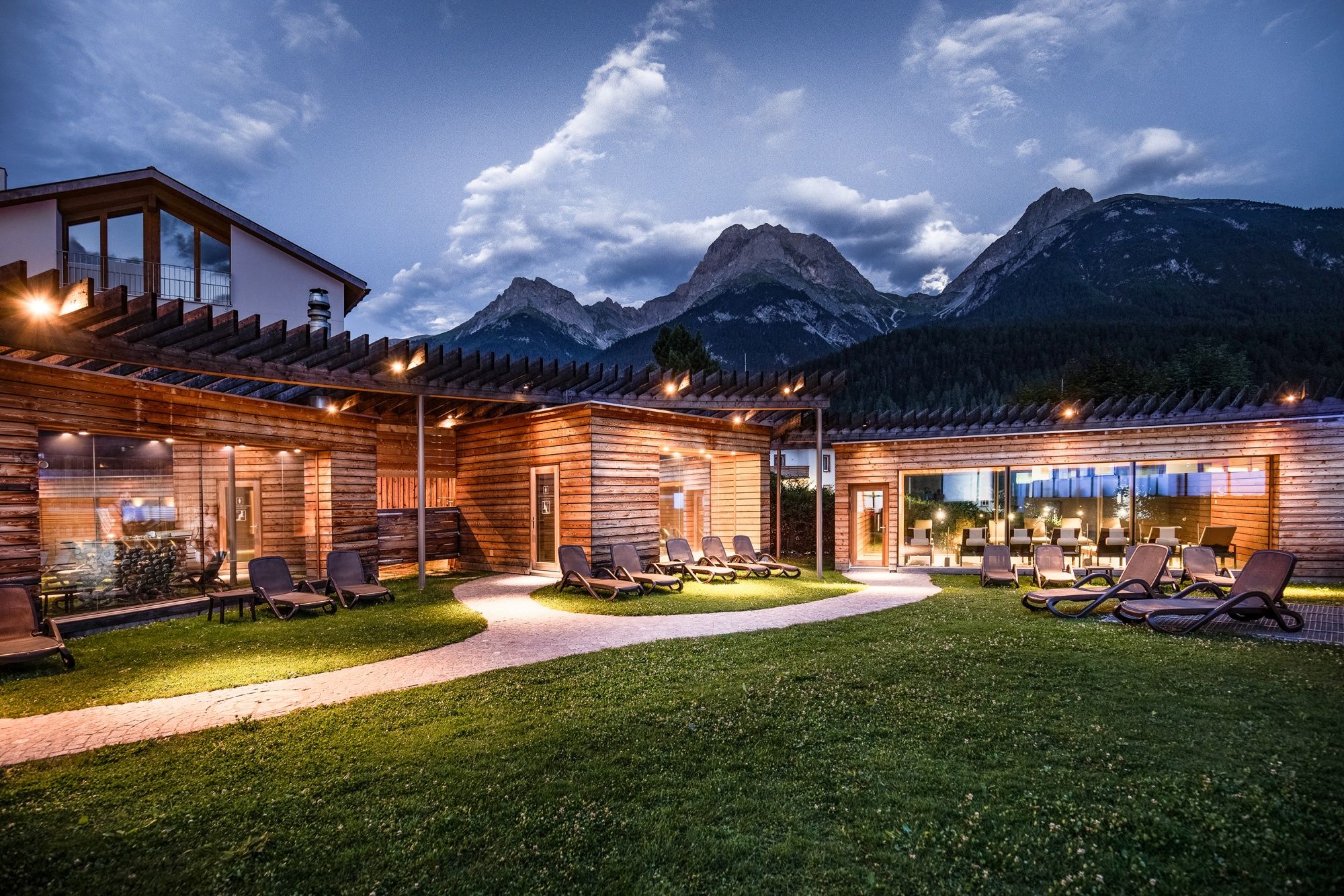 Bastulandskap utomhus med avkopplande solstolar och utsikt över bergen i Engadin