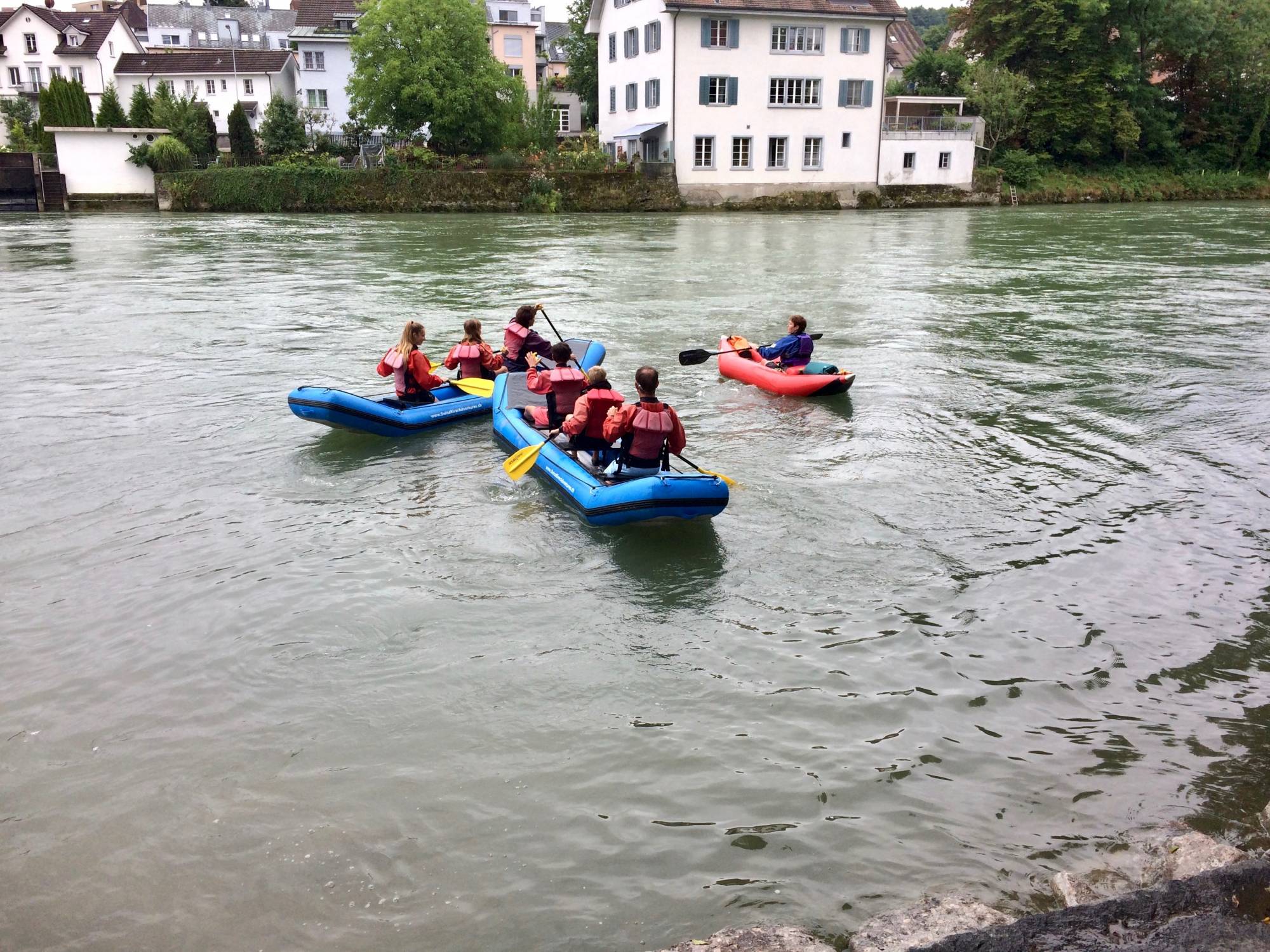 Bootsfahrt Reuss mit Kajaks auf dem Gewässer, umgeben von bunten Häusern.