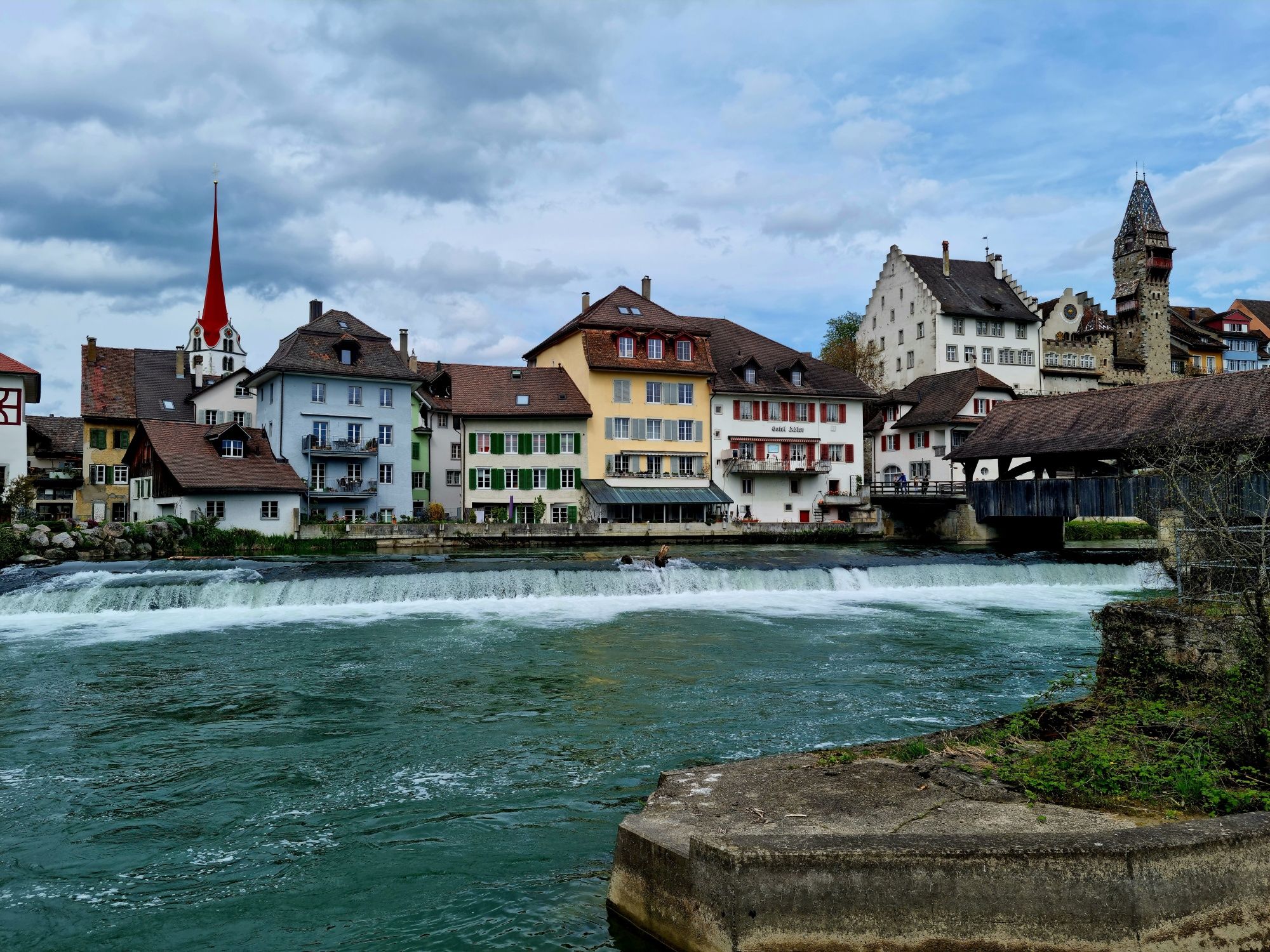 Bremgarten: malerische Altstadt mit historischen Gebäuden und sichtbarem Wasserfall. Ideal für Erholung und Kunst.
