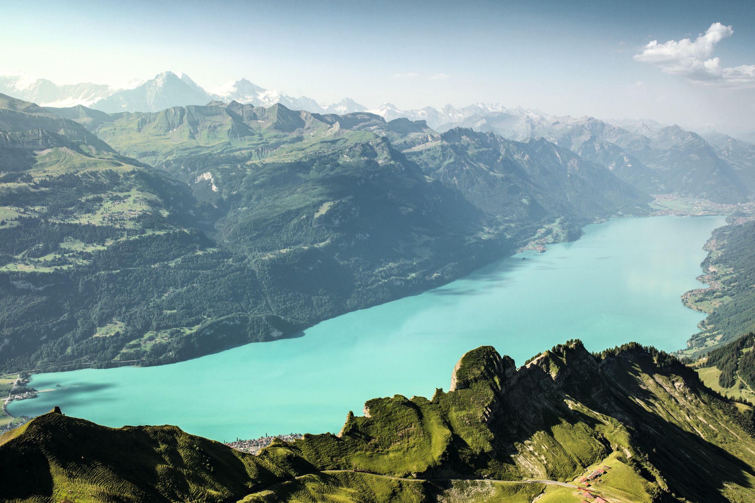 एक परेल नीलाबी लेक ब्रिएनज, हरियाली से घिरे पहाड़ों से घिरा हुआ