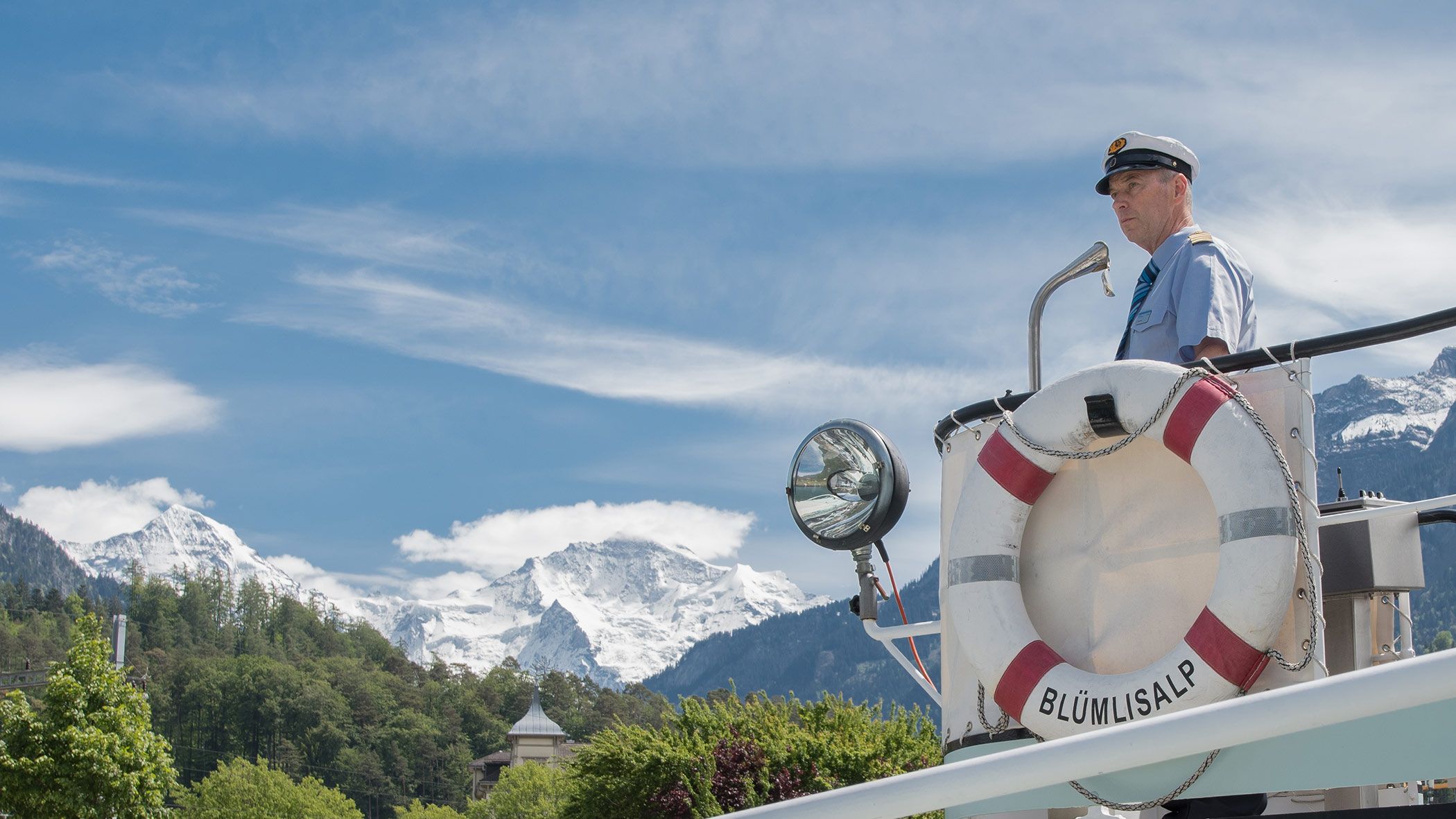 Pelancongan Kapal di Tasik Brienz dengan Kapten di atas bot, latar belakang gunung