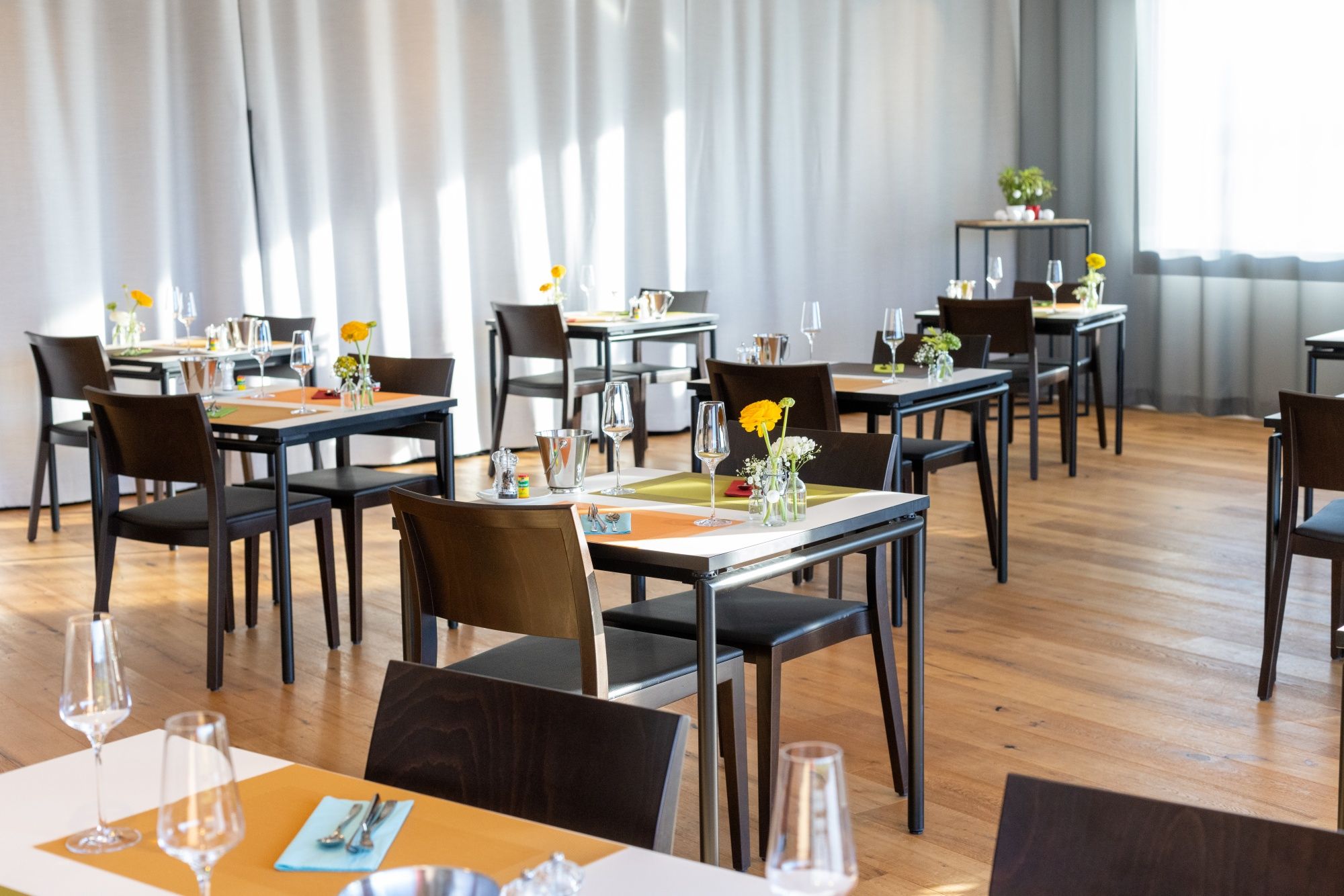 ब्रंच: आधुनिक रेस्टोरेंट में फूलों के साथ आरामदेह टेबल साज-सज्जा।