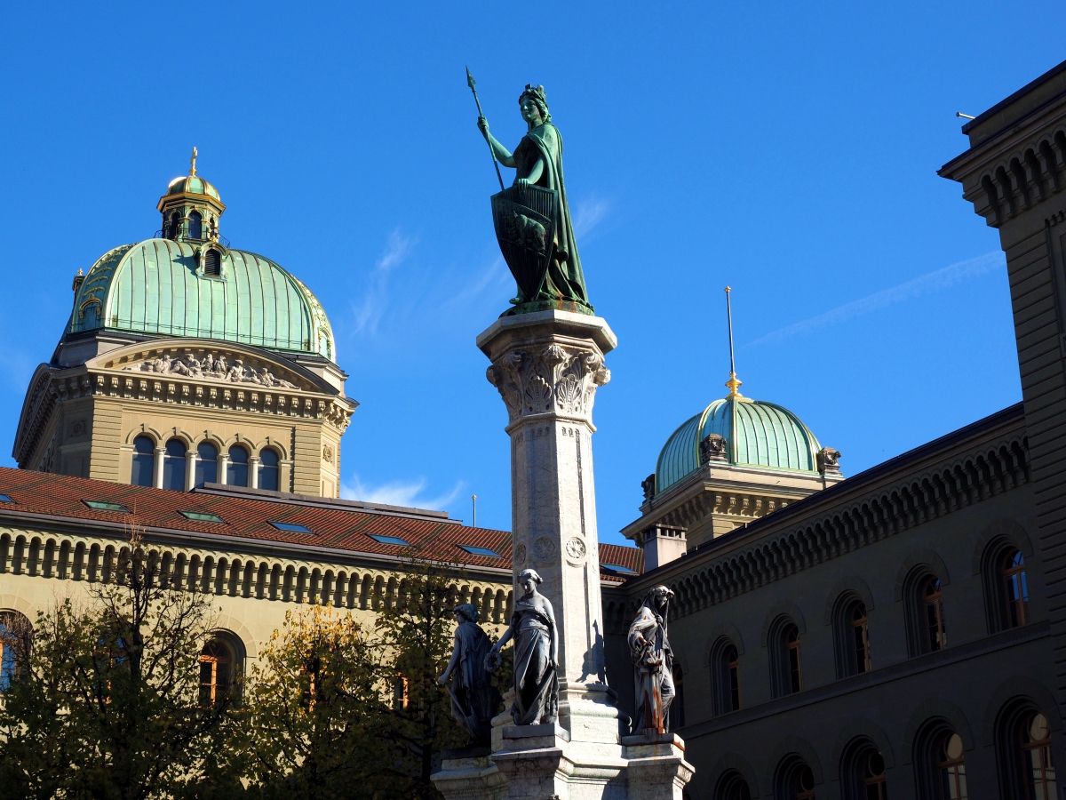 Bundeshaus Bern mit Statue und klarem Himmel