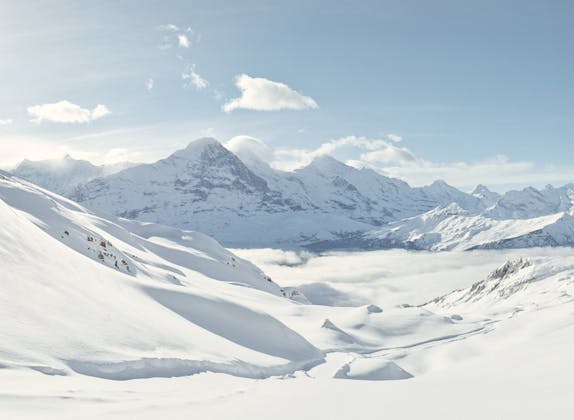 Seluncur salju dari Grindelwald First dengan pemandangan Eiger dan Jungfrau di musim dingin.