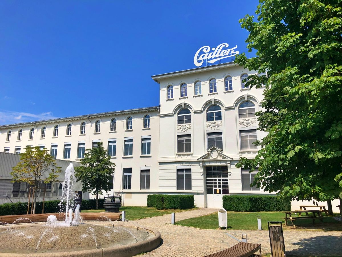 Maison Cailler i Broc med springvand og bygningsfacade.