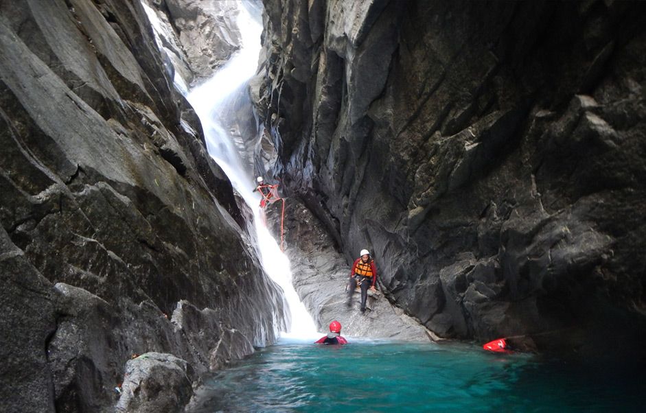 Canyoning di Alpen Swiss dengan gelongsor air dan tebing. Alami pengembaraan di alam semula jadi.