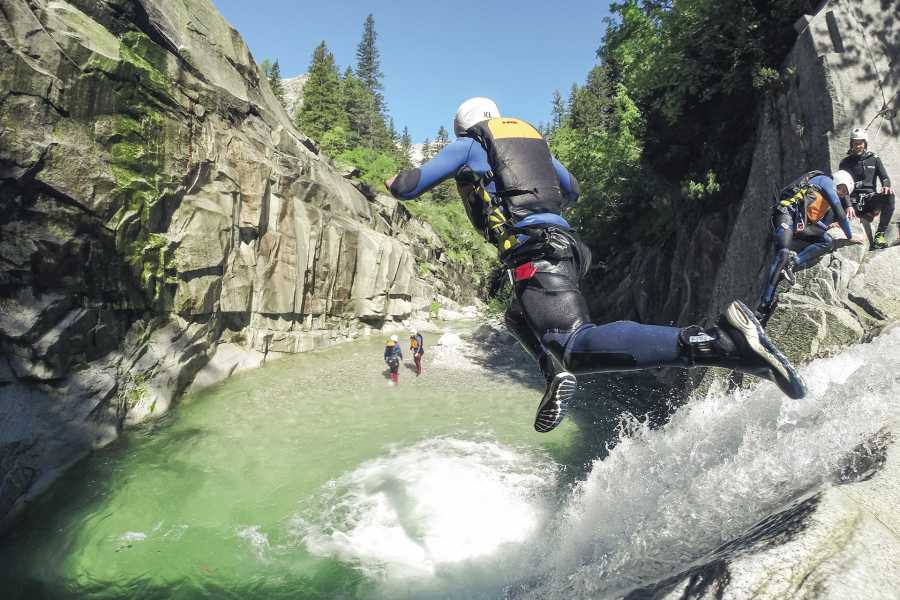 Canyoning Grimsel Jump, participants jump into the water, river and rocks visible