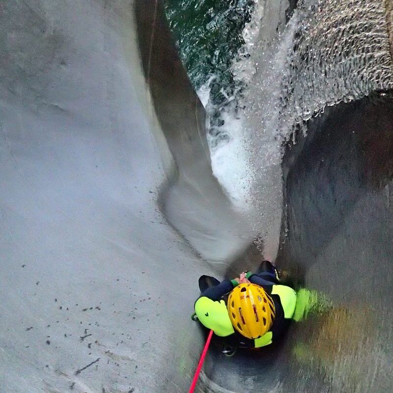 Vodní skluzavka při canyoningu v Lodrino, stříkající voda a kameny
