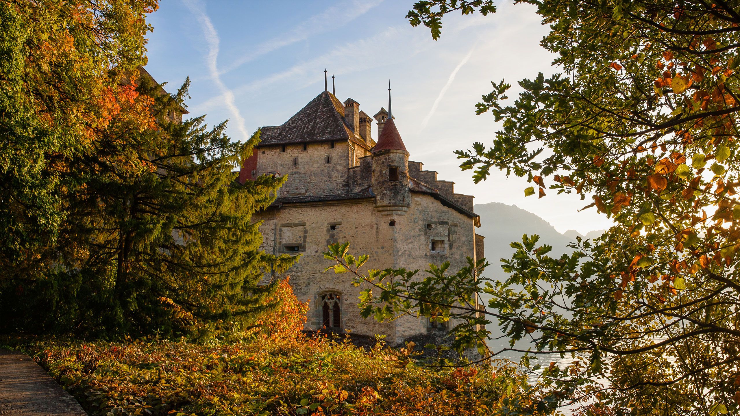 Chateau Chillon pada musim luruh, dikelilingi daun-daun berwarna-warni dan cahaya lembut