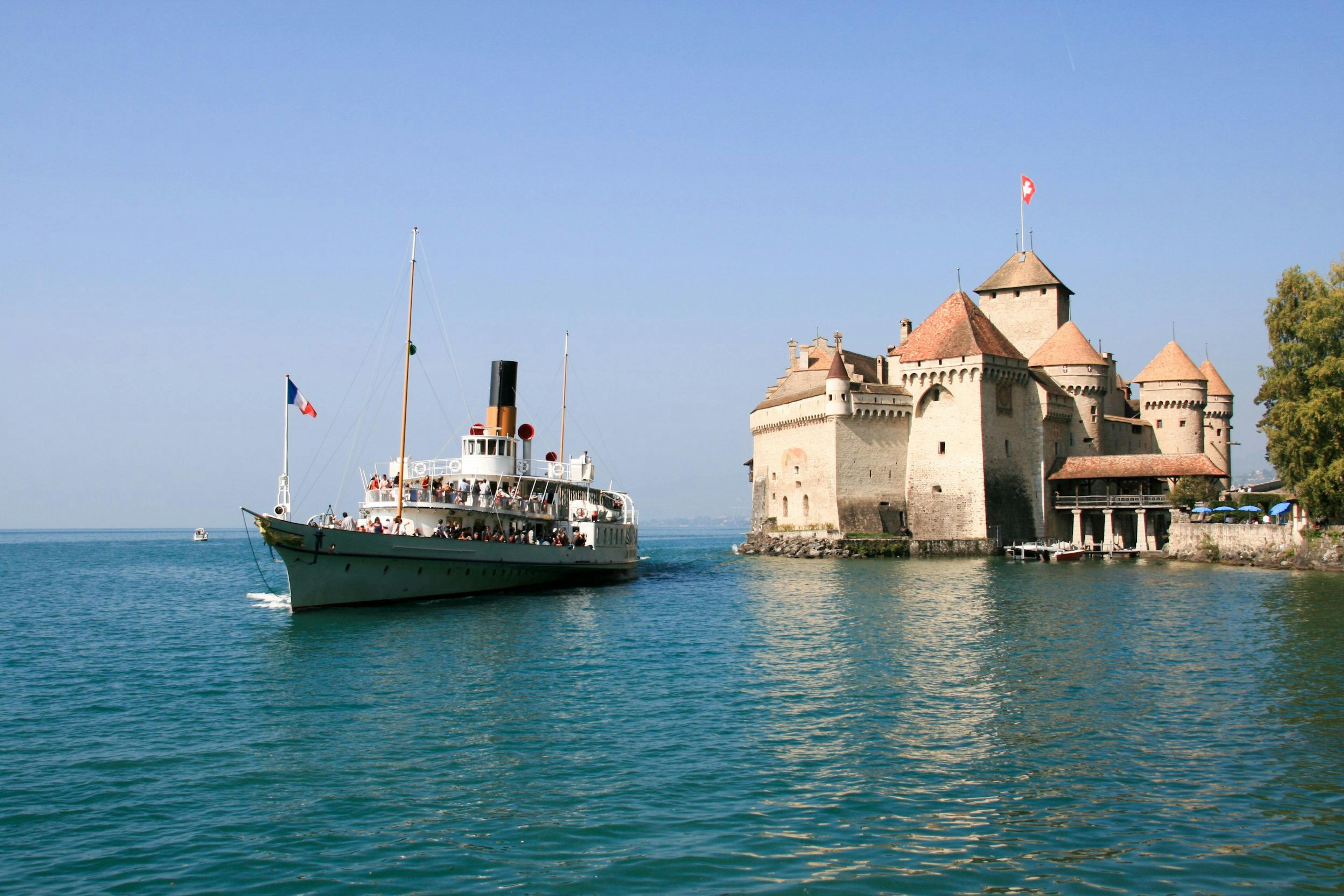 Zamek Chillon z parostatkiem na Jeziorze Genewskim, czyste niebo, letnia aktywność.