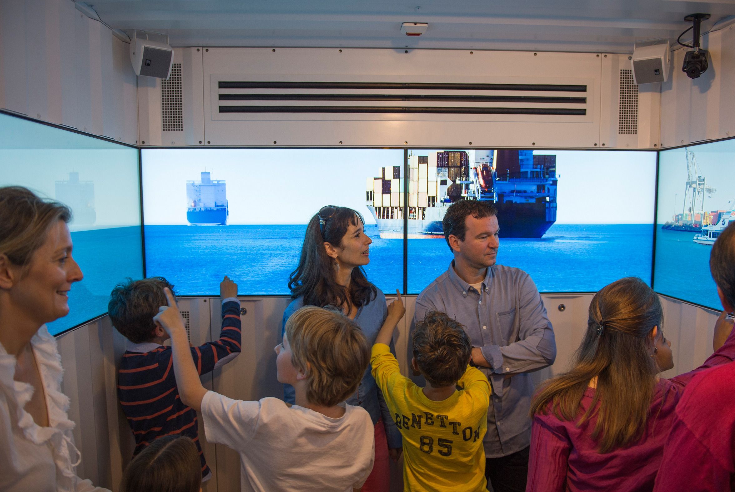 Los visitantes observan barcos de carga tras el cristal durante la exposición Chocolate Adventure.