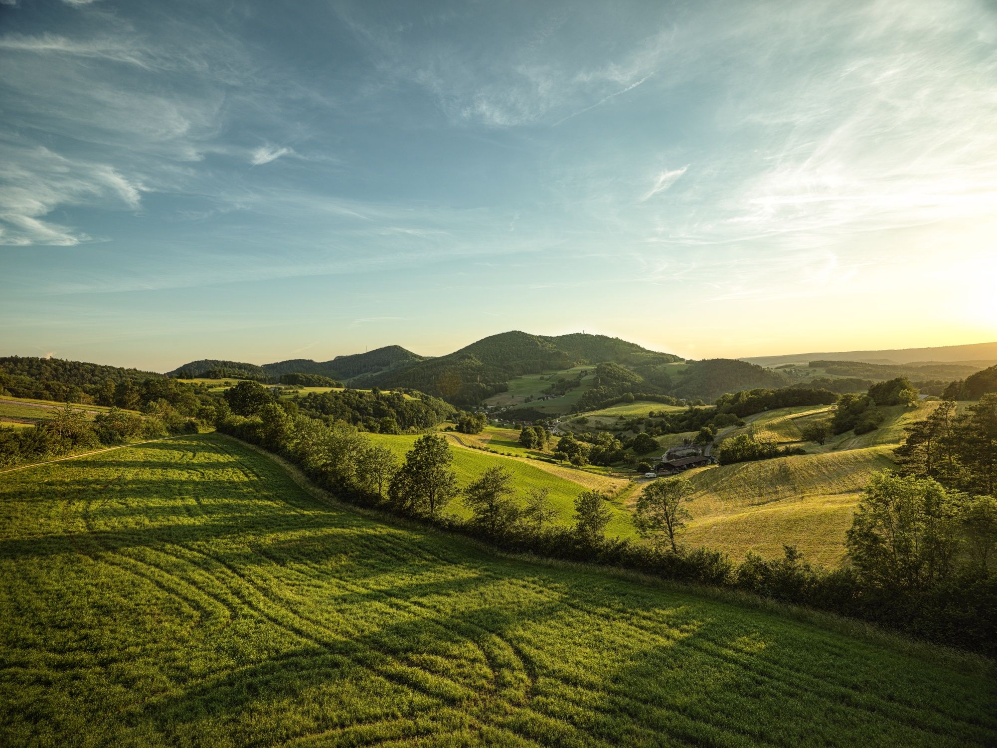 Urmeer Jurapark Chriesiweg: ทิวทัศน์ที่สวยงามพร้อมทุ่งหญ้าเขียวขจีและเนินเขาเรียบในอุทยานธรรมชาติ.