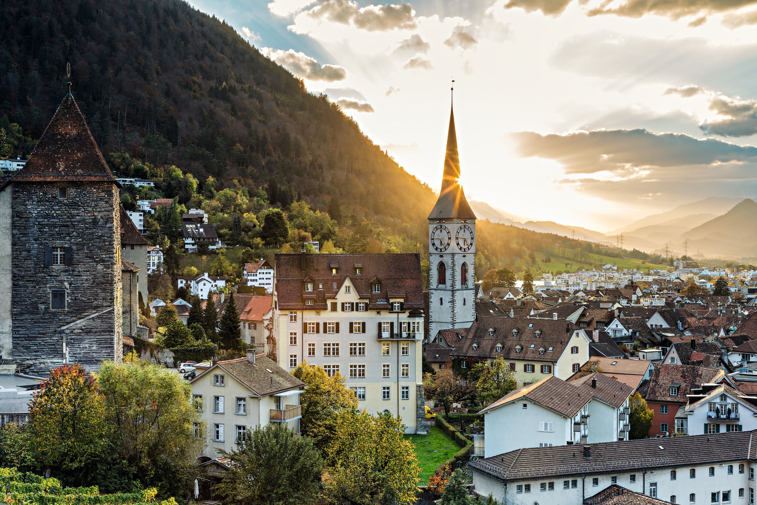 Městský pohled na Chur při západu slunce, historické budovy, příroda