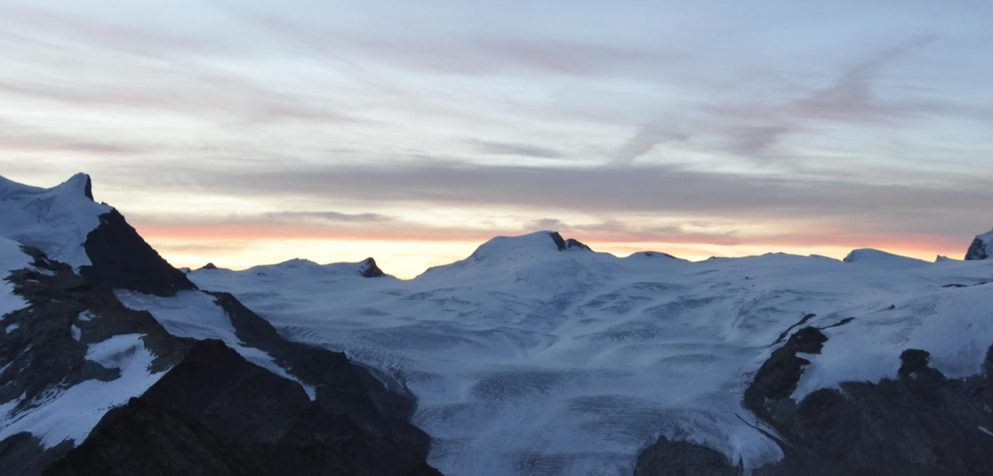 Skitour Cima di Jazzi Panorama avec des montagnes enneigées et un coucher de soleil impressionnant.