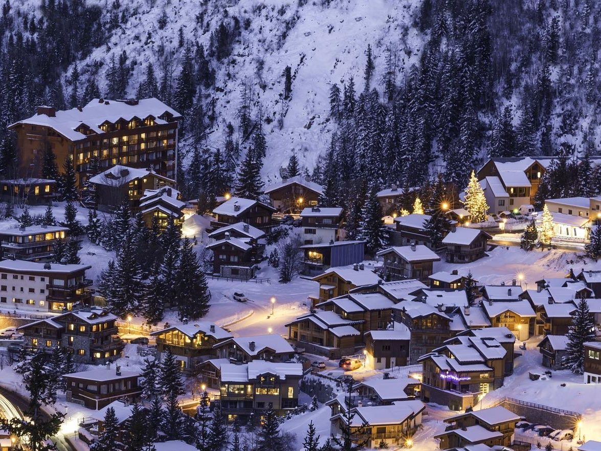 Courchevel: Paisaje invernal de los Alpes con cabañas nevadas y vistas de montañas en los Alpes franceses.