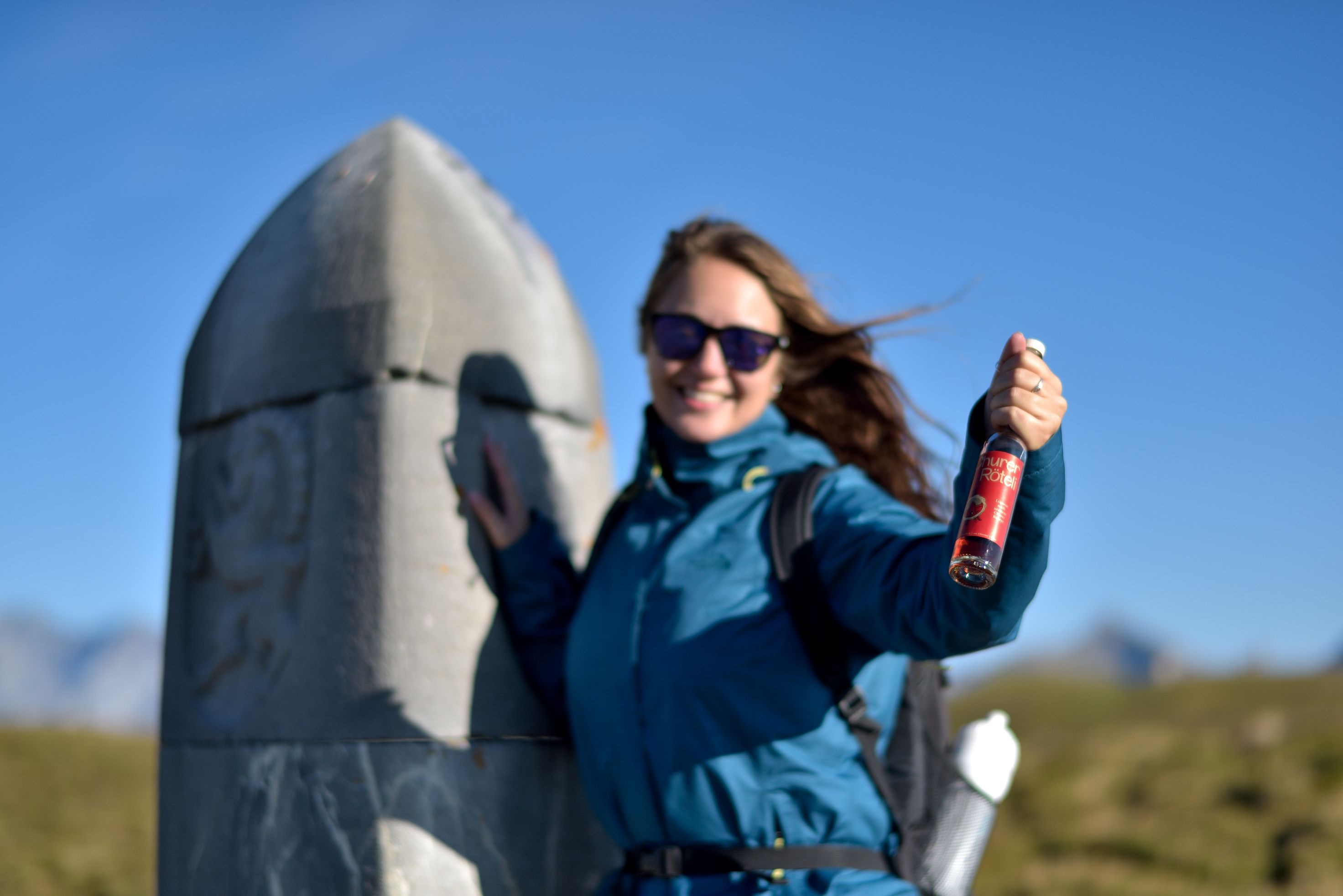 Caminata de placer Dreibündenstein, mujer con bebida, vista desde la cima, cielo cubierto de azul