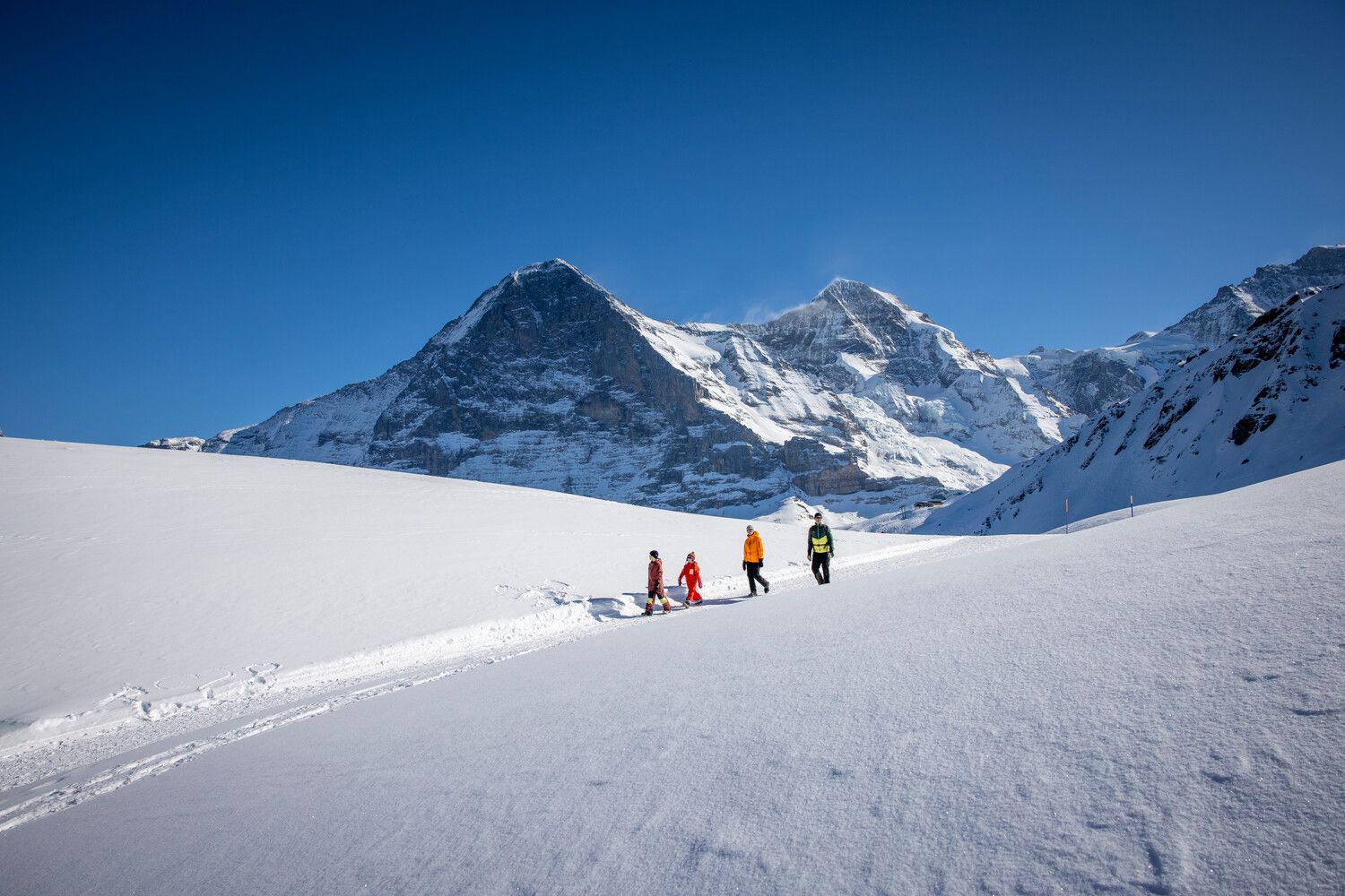 Wandern im Winter in den Bergen mit Familie und Freunden auf dem Schnee