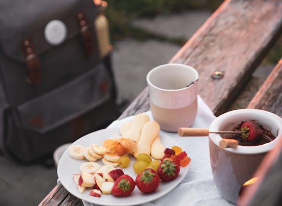 Čokoládové fondue s čerstvým ovocem na talíři v přírodě u Rigi.