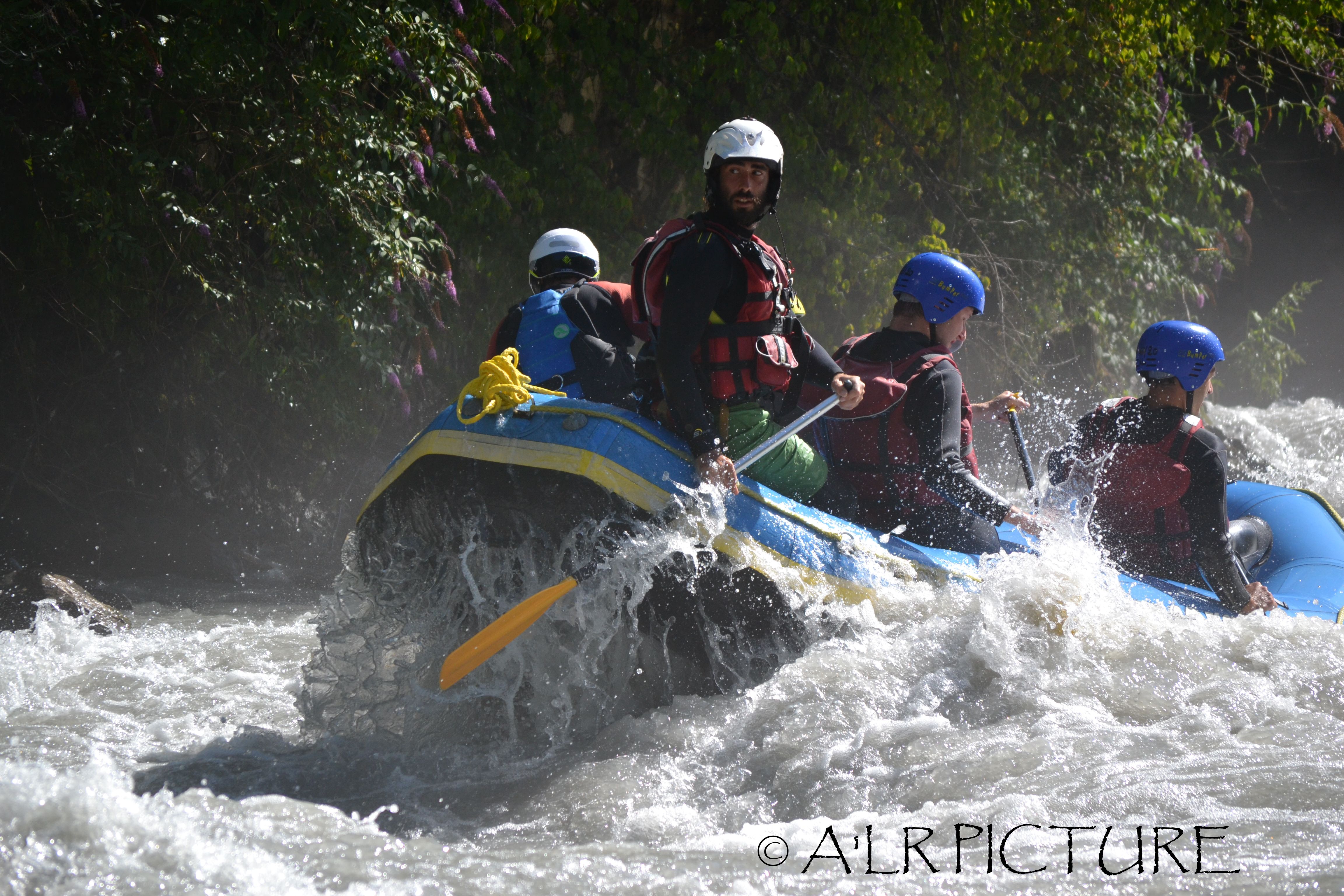 Avventura di rafting in acque bianche con i kayakisti nel fiume.