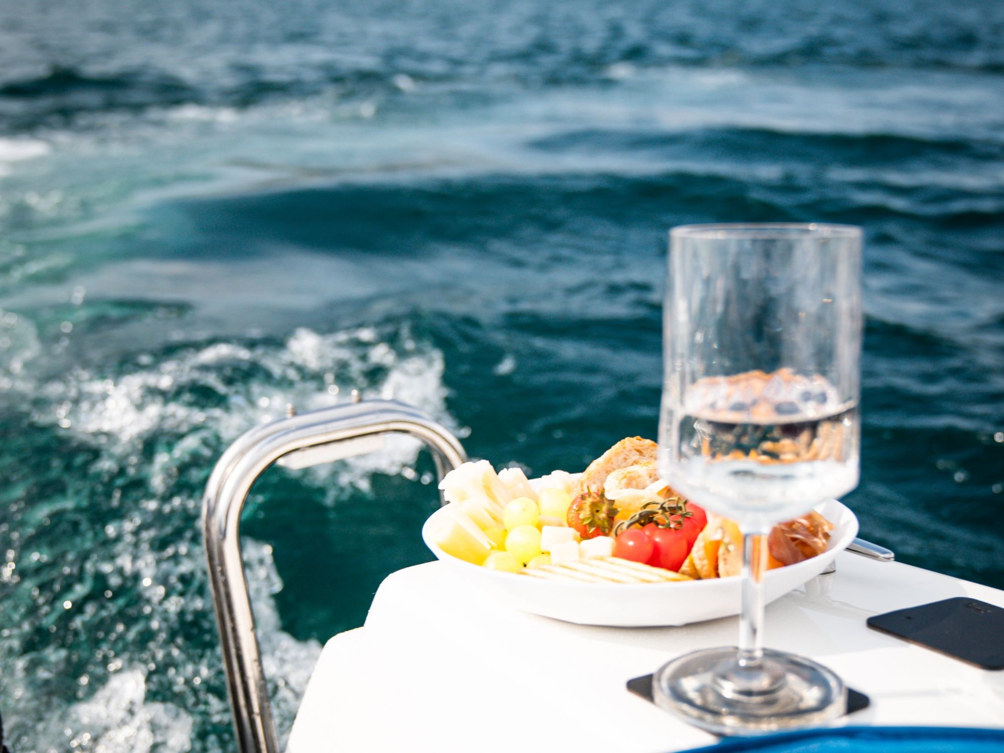 Apero na pikniku u čamcu s svježim voćem i pićima na vodi.