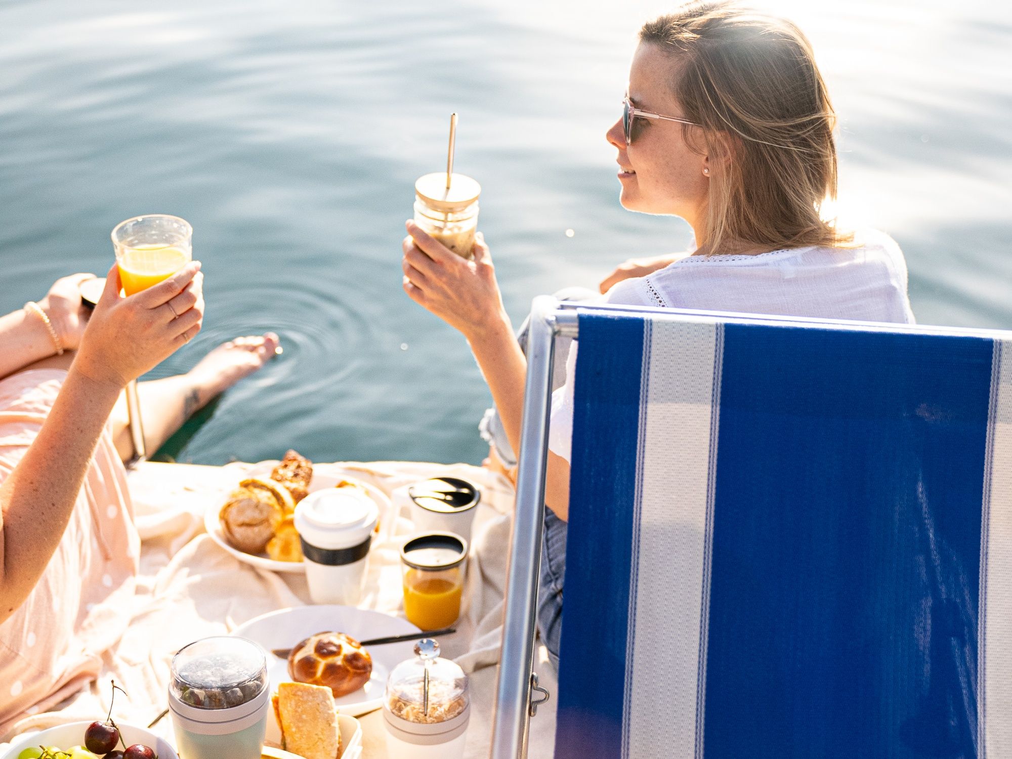 Pedálková snídaně u vody s přáteli, osvěžujícími nápoji a chutným pečivem.