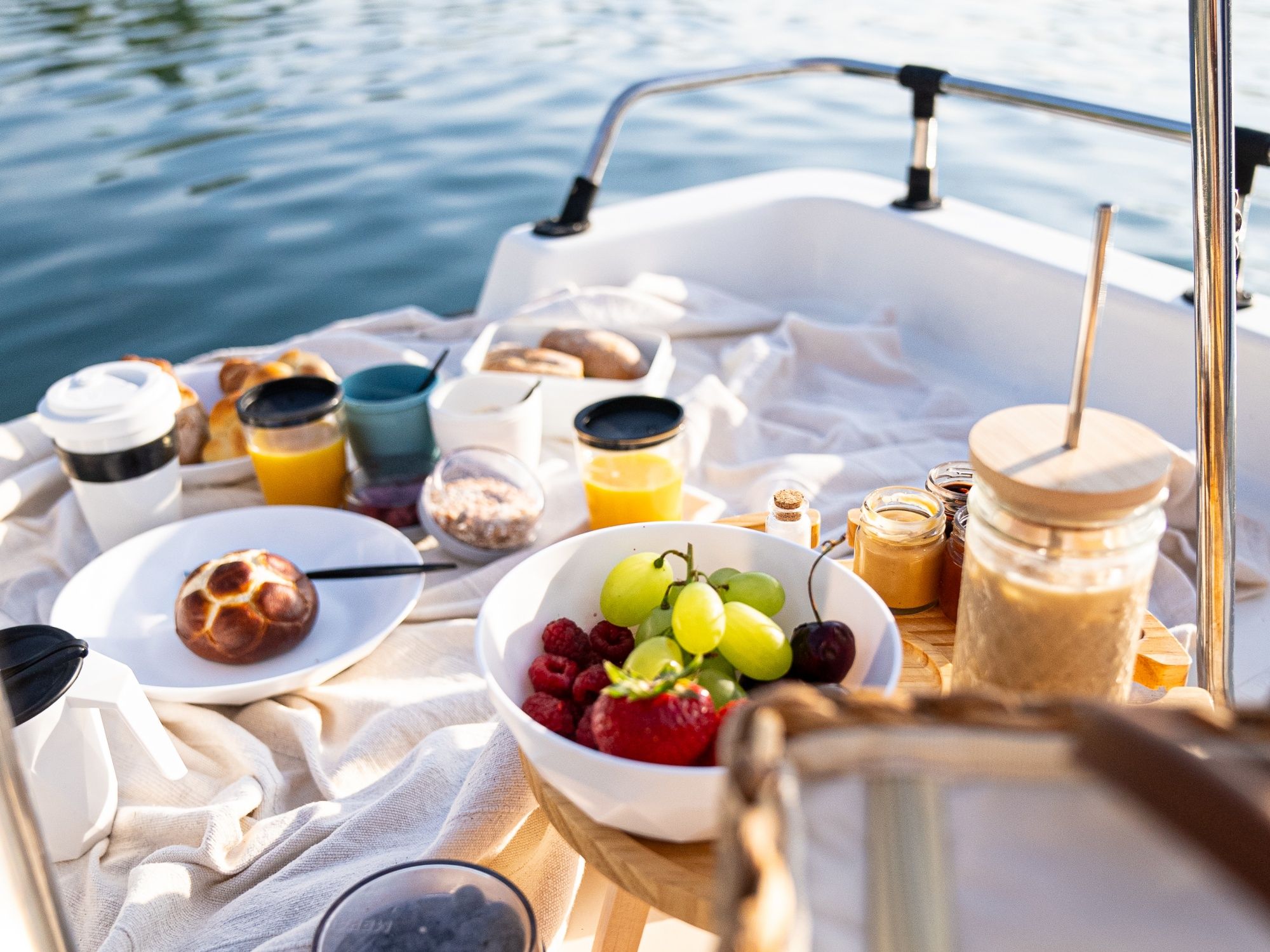 Pedálování na snídani na vodě s čerstvým ovocem, džusem a chlebem za slunečného počasí.