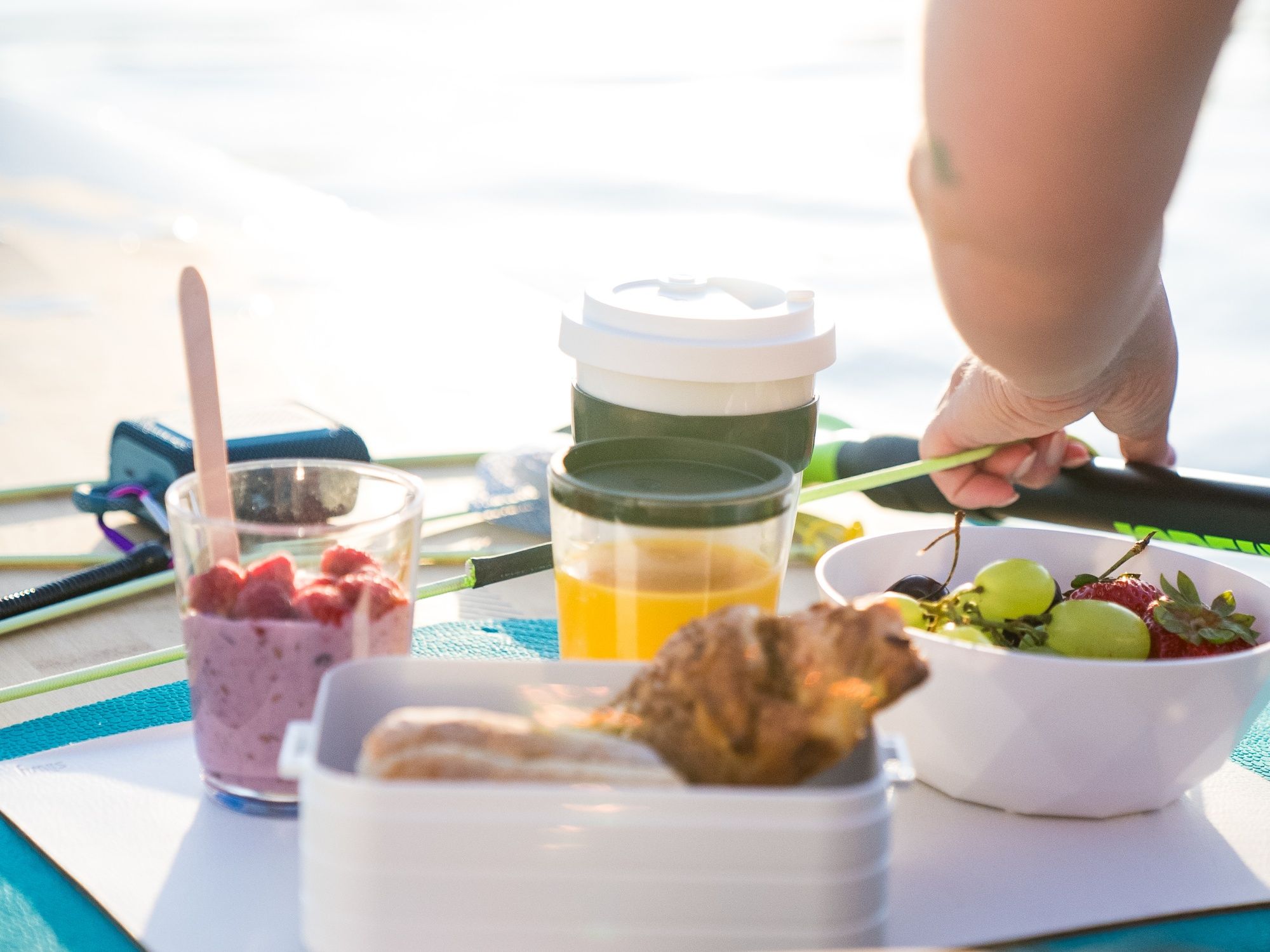Desayuno SUP con snacks frescos, frutas saludables y bebidas junto al agua para un comienzo perfecto del verano.